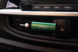 Car air freshener with 'Millefiori Milano' branding in a car's air vent.